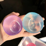 Two coconut oil squishy balls holding the dents pressed into them